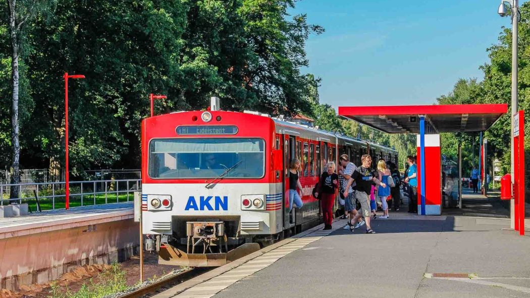 Menschen steigen aus einem AKN-Triebwagen am Haltepunkt Burgwedel in Hamburg