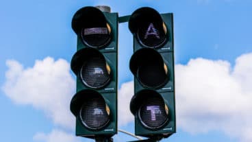 Ampelvorrangschaltung für Busse in Hamburg. Das leuchtende A bedeutet, dass der Bus an der Ampel Grünlicht angefordert hat, das T signalisiert dem Busfahrer in der Haltestelle, dass er die Türen schließen soll, um rechtzeitig bei Grünlicht abfahren zu können