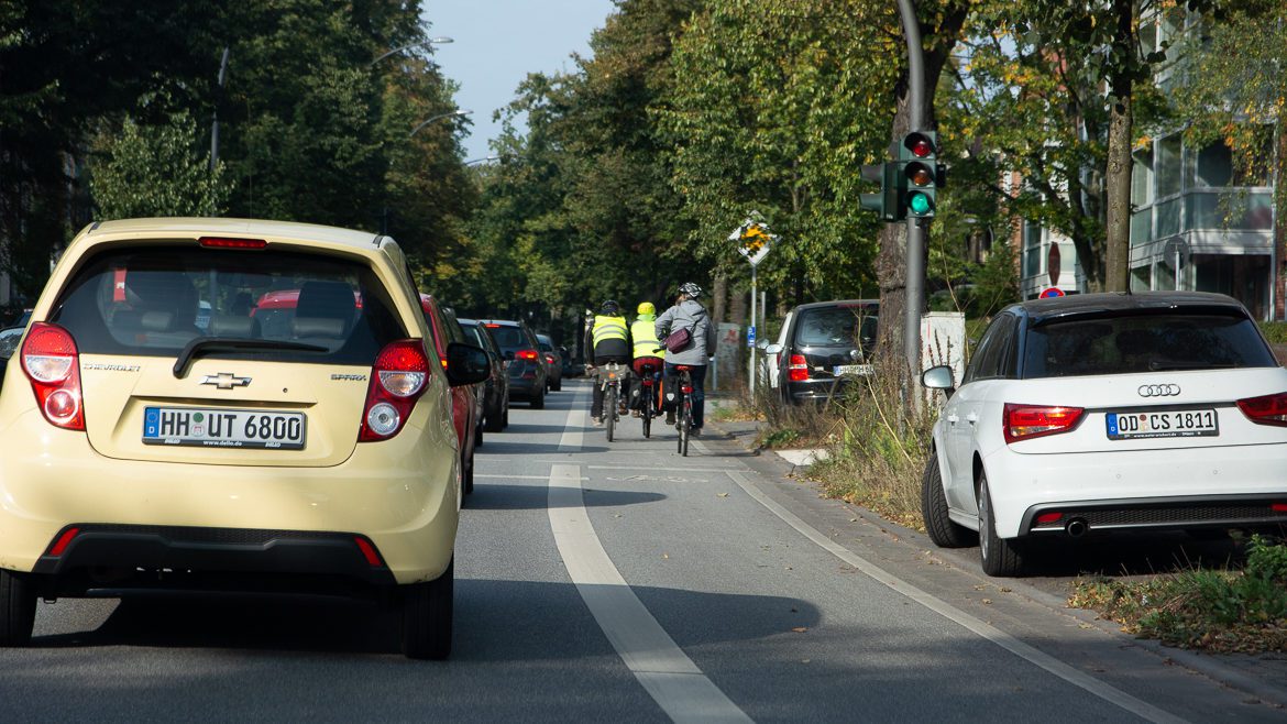 Fahrradfahrer fahren auf einer vom Autoverkehr abgetrennten Radspur in Hamburg