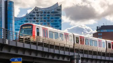 Ein U-Bahnzug vom Typ DT5 auf der Linie U3 vor der Elbphilharmonie in Hamburg