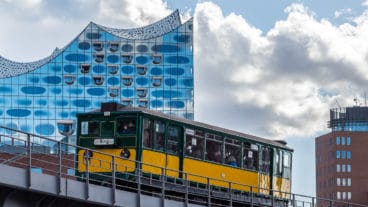 Ein historischer U-Bahnzug vom Typ T auf der Linie U3 vor der Elbphilharmonie in Hamburg