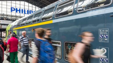 Menschen laufen im Hamburger Hauptbahnhof vor einem Doppelstock-Zug der Deutschen Bahn