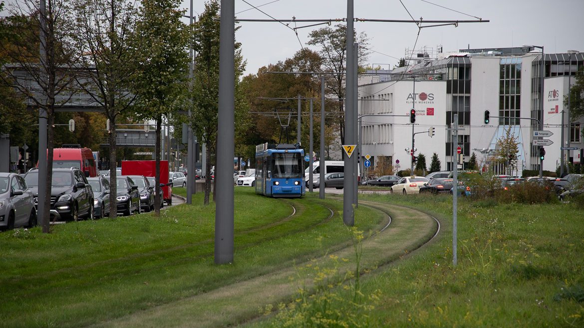 Eine Straßenbahn fährt in München an einem Stau vorbei