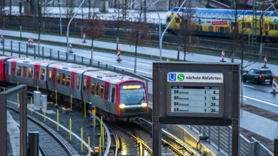 Display mit Anzeige der nächsten Abfahrten im U-Bahnhof Elbbrücken in Hamburg - im Hintergrund eine U-Bahn