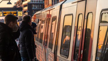Menschen stehen am U-Bahnhof Baumwall in Hamburg.